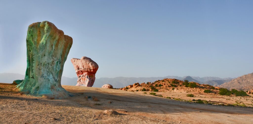 View of the iconic painted rocks in Tafraoute, Morocco, under a clear sky.
